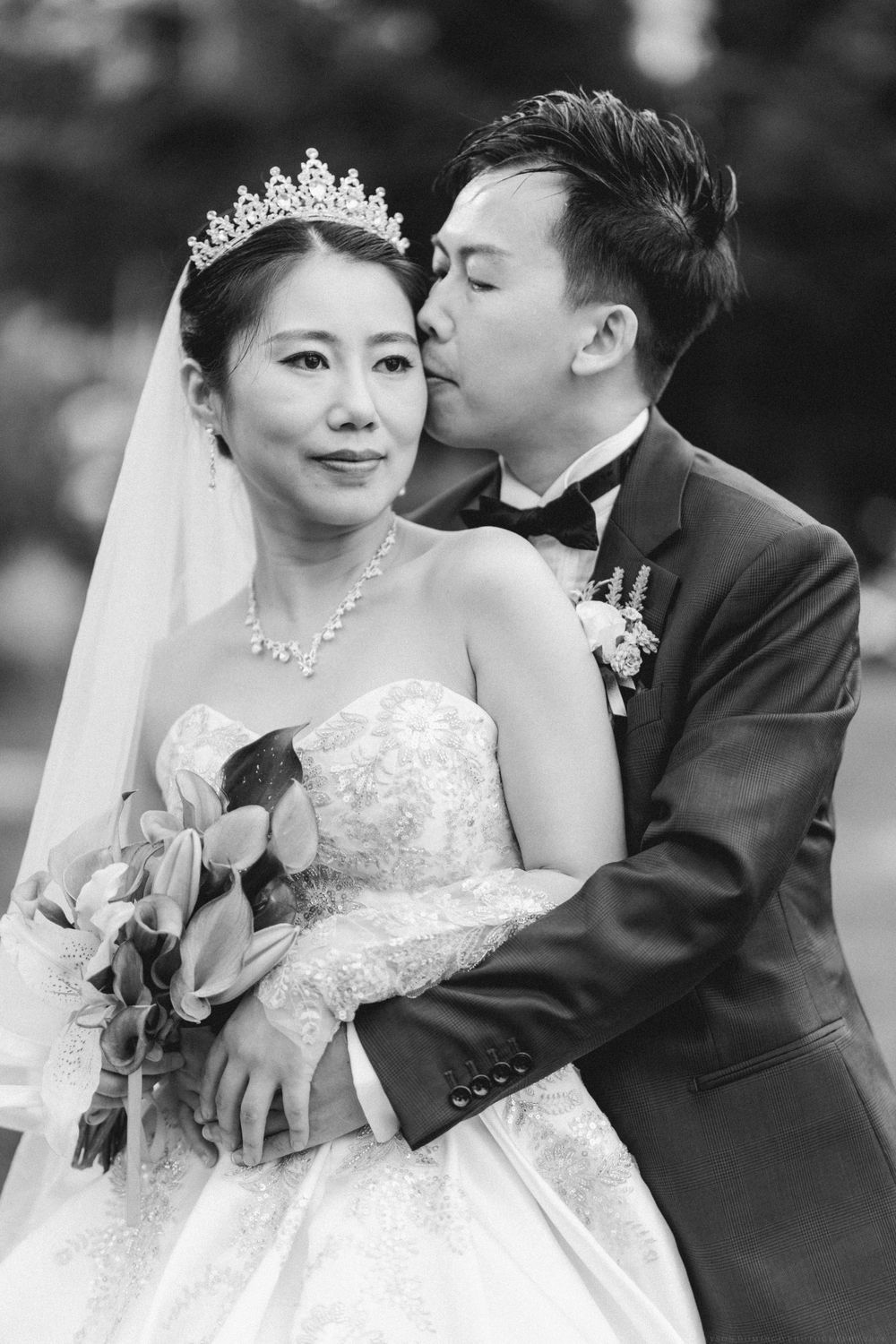 A tender wedding portrait with the bride wearing a crystal crown and elegant white gown.
