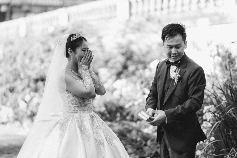 Emotional black and white wedding moment as couple exchanges rings in an outdoor ceremony.