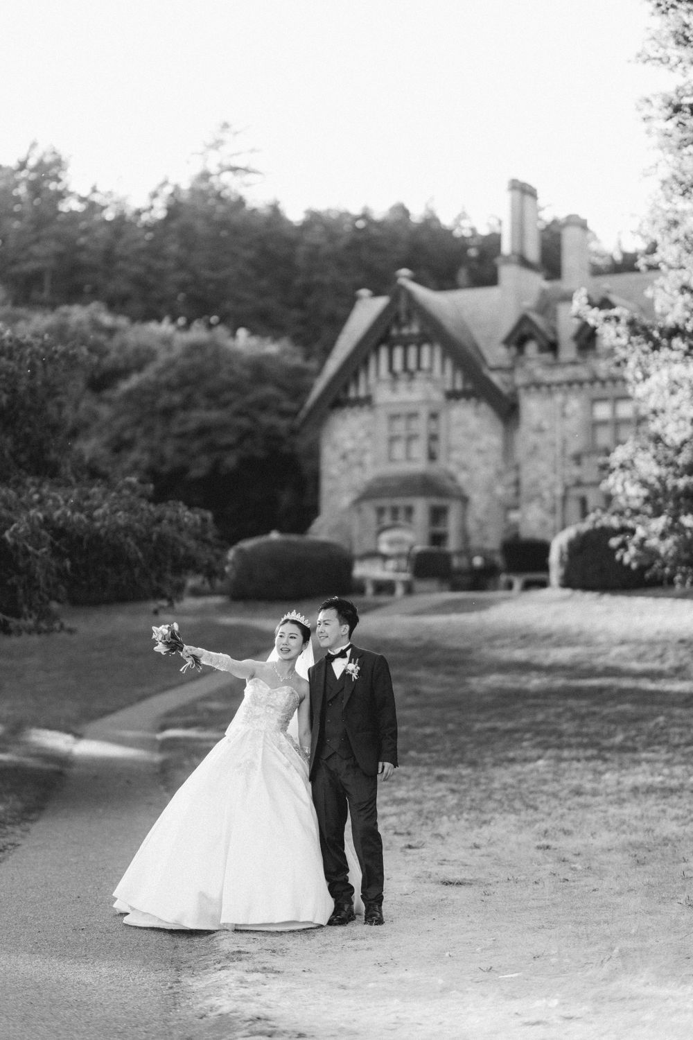 Black and white wedding portrait in front of a historic manor house.