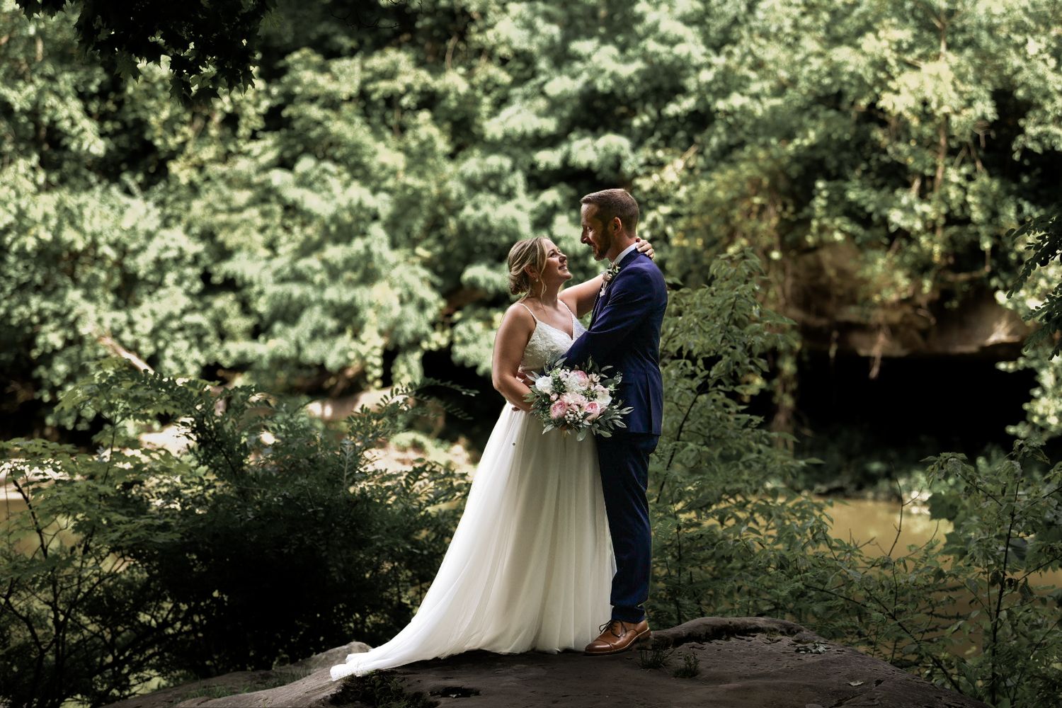 Wedding ceremony setup in lush garden setting with natural greenery.