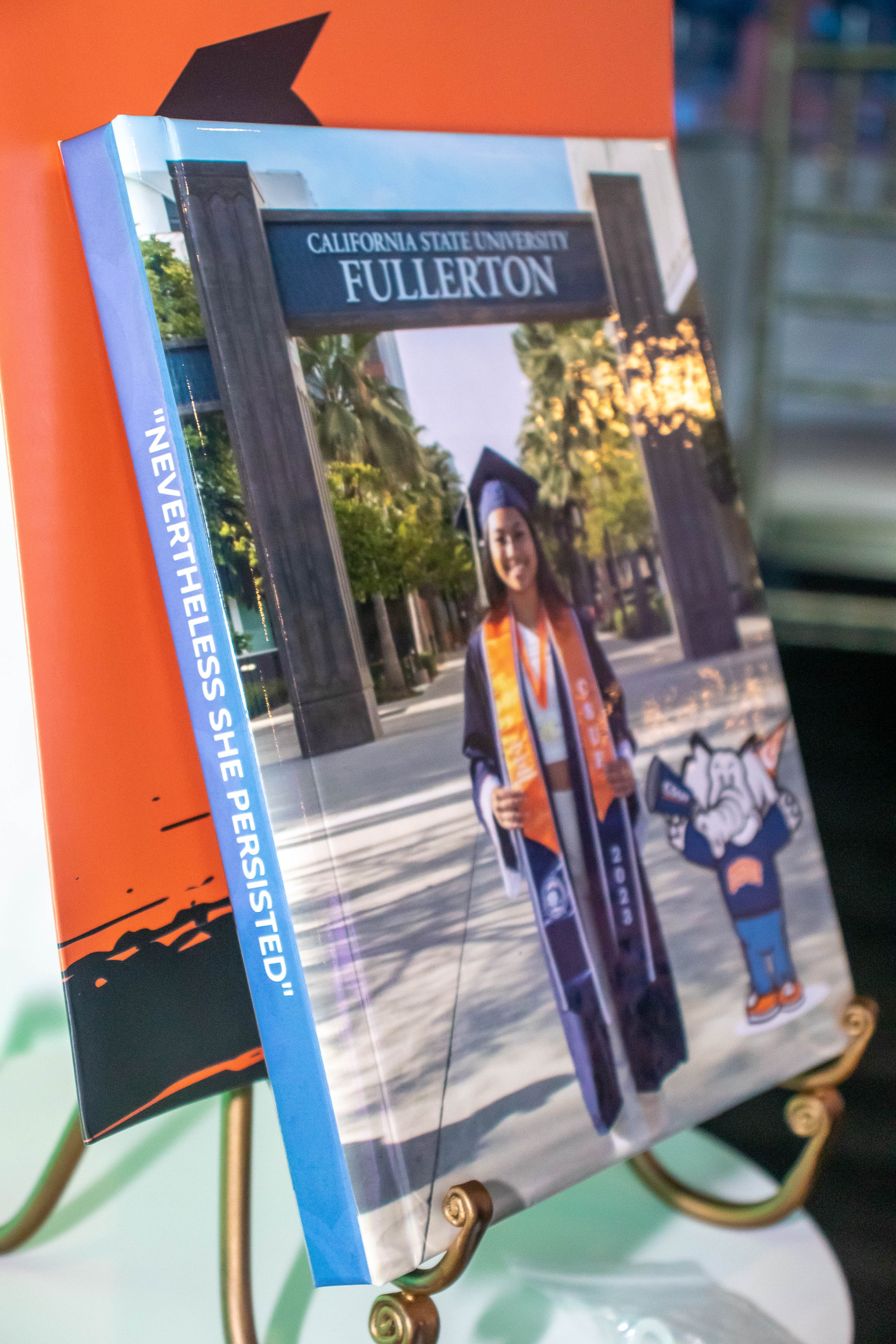 Display of graduation photos from California State University Fullerton mounted on decorative stands.