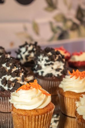 Close-up of decorated cupcakes topped with white frosting and chocolate cookie crumbles.