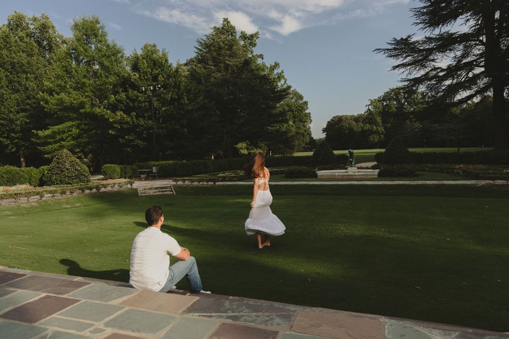 A playful moment captured on a stone patio with someone dancing on the lawn.