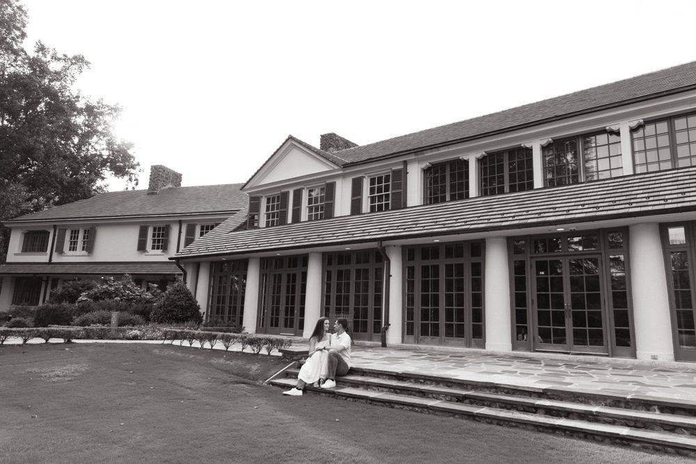 Grand colonial-style house with white columns and large windows on a sunny day.