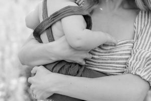 Close-up black and white shot showing gentle embrace between parent and child.