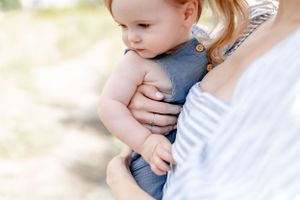 Soft, intimate photograph showing loving parental embrace in natural lighting.