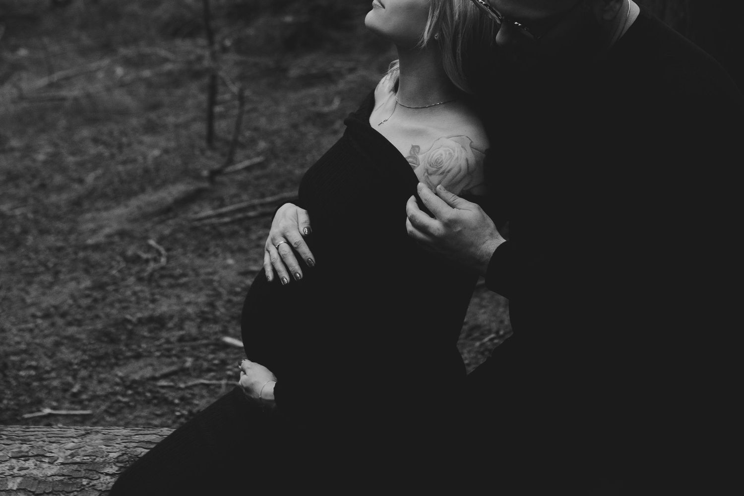 Expecting parents embracing in the New Forest, with the forest creating a calm, natural backdrop.