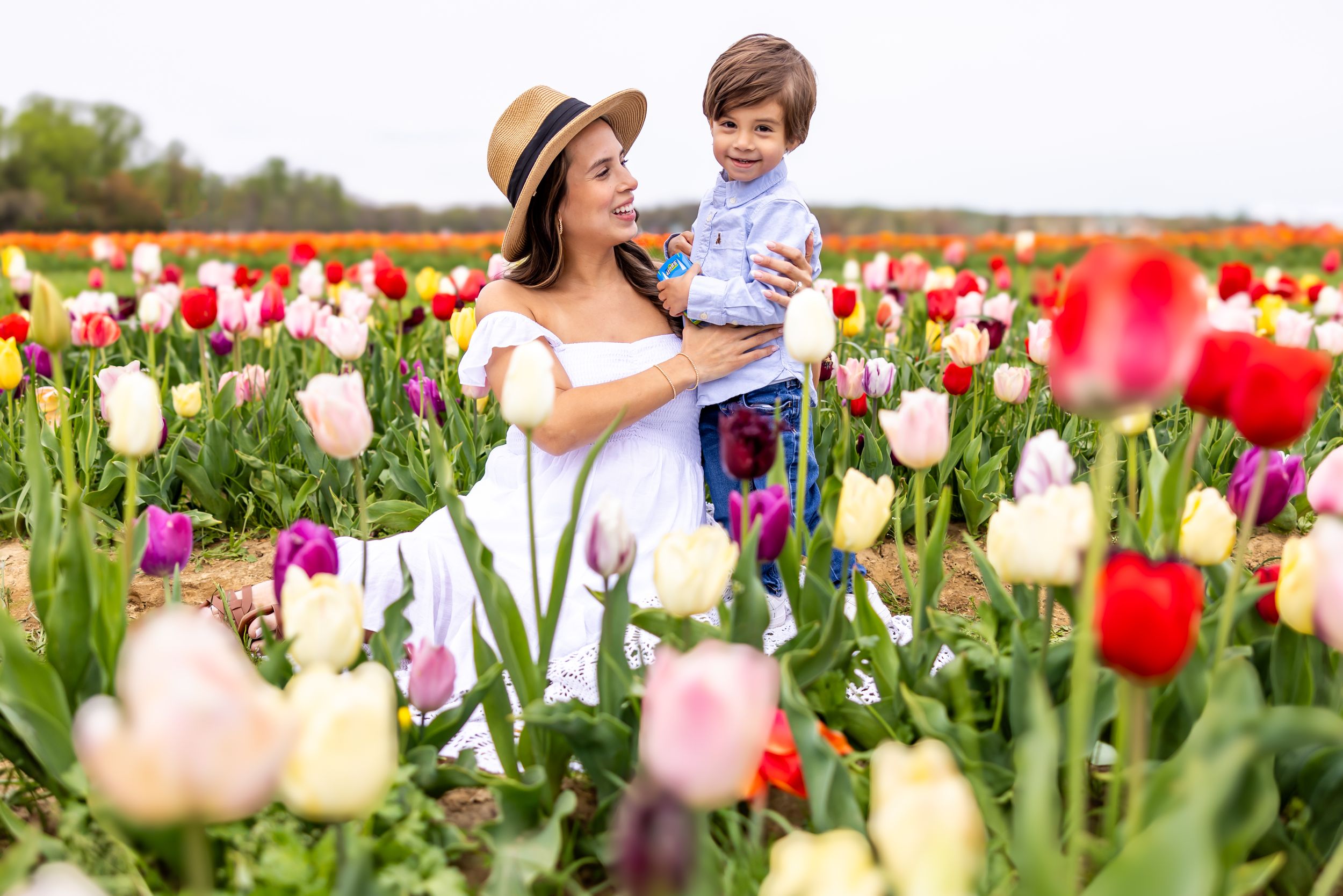 Joyful springtime moment among colorful tulip fields with bright red and white blooms.
