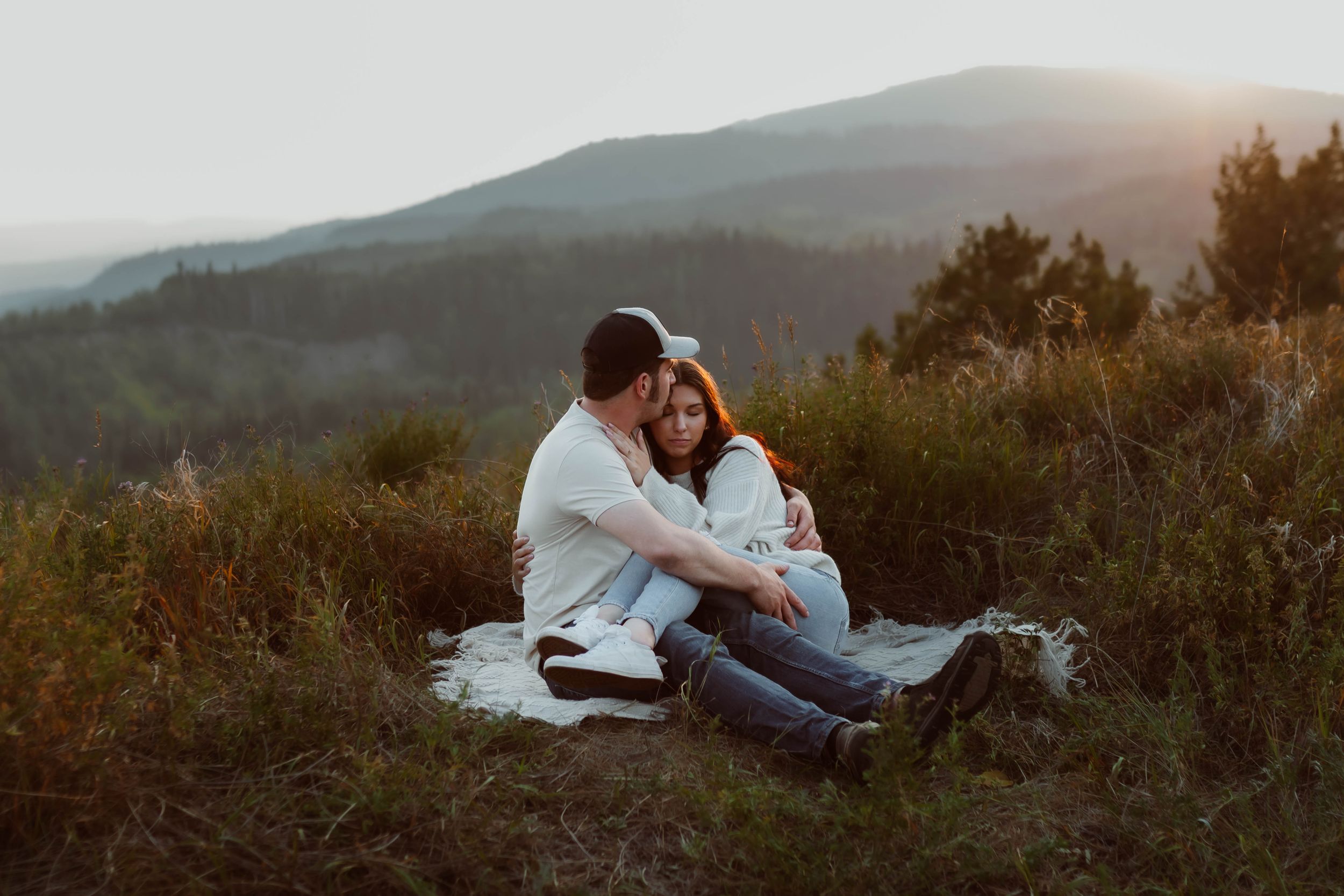 Wide landscape shot of couple during mountain engagement session at sunset.