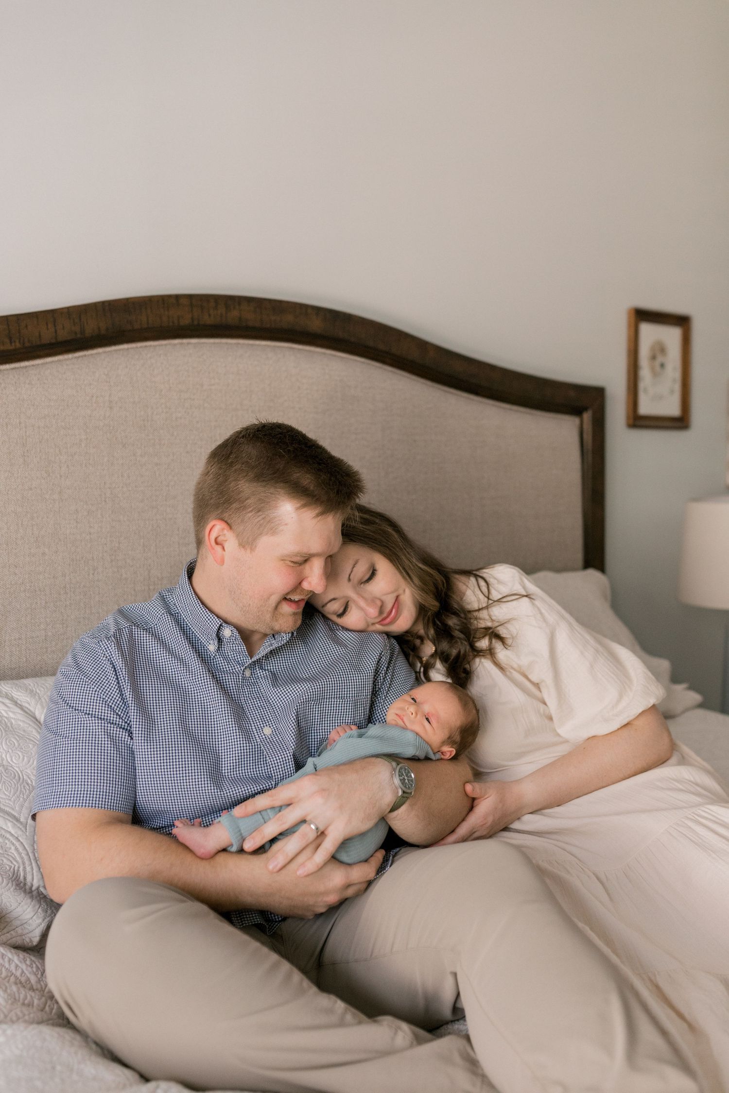 Family sharing intimate moment together on bed with newborn.