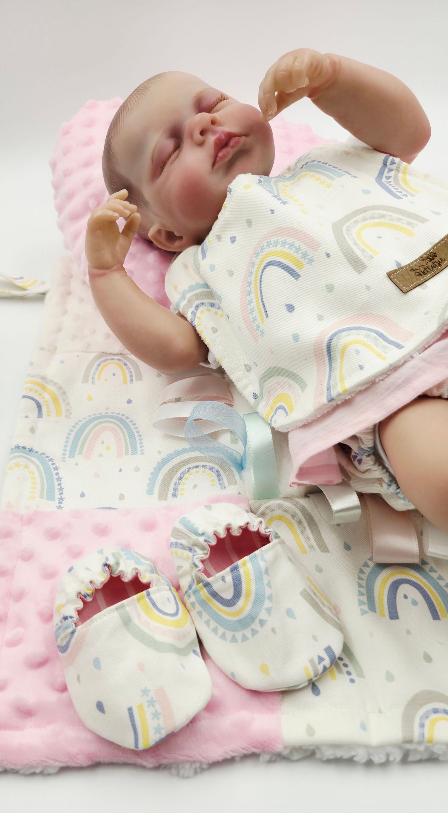 Soft baby blanket with rainbow pattern and minky fabric shown with matching accessories.