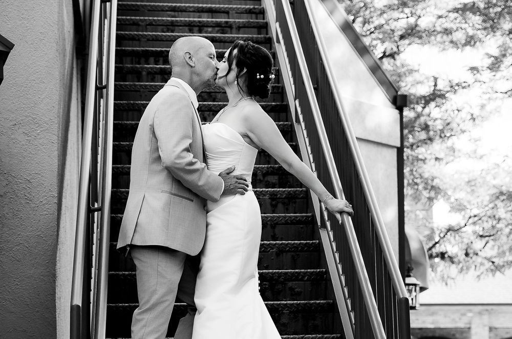 A romantic black and white photo series showing a couple sharing intimate moments on a staircase.