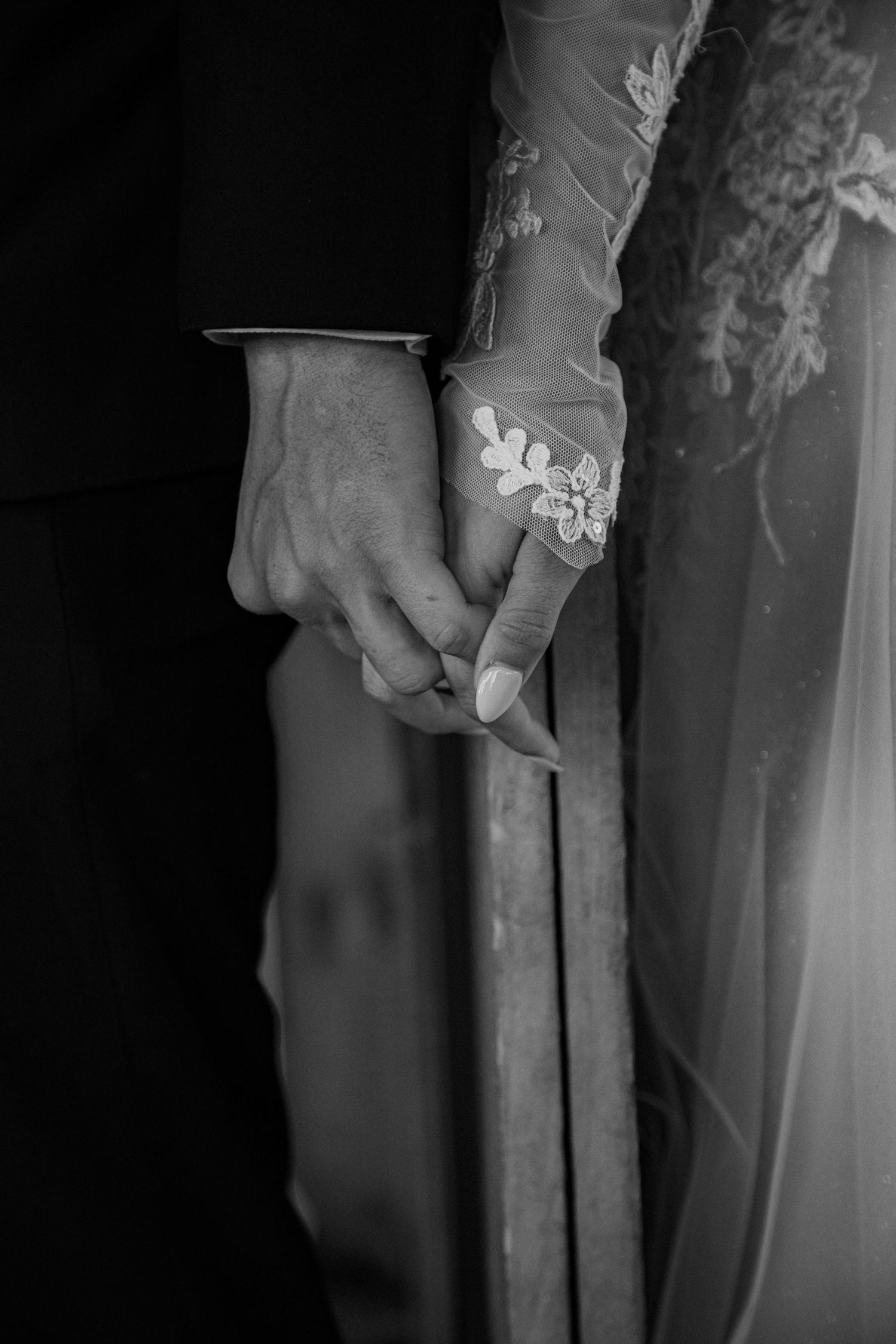 Intimate black and white portrait of a couple embracing outdoors.