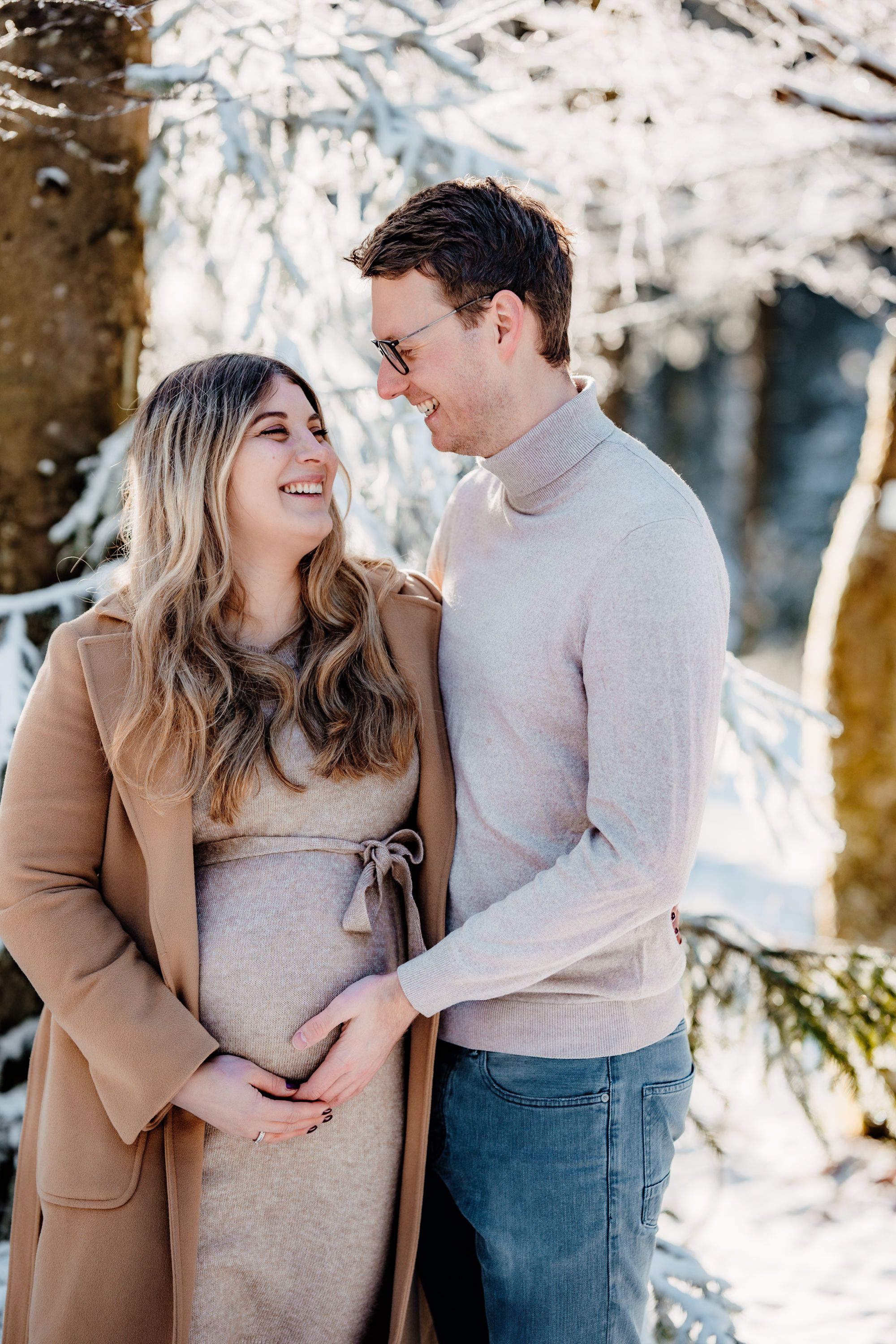 Couple sharing a joyful moment together in a snowy winter wonderland setting.