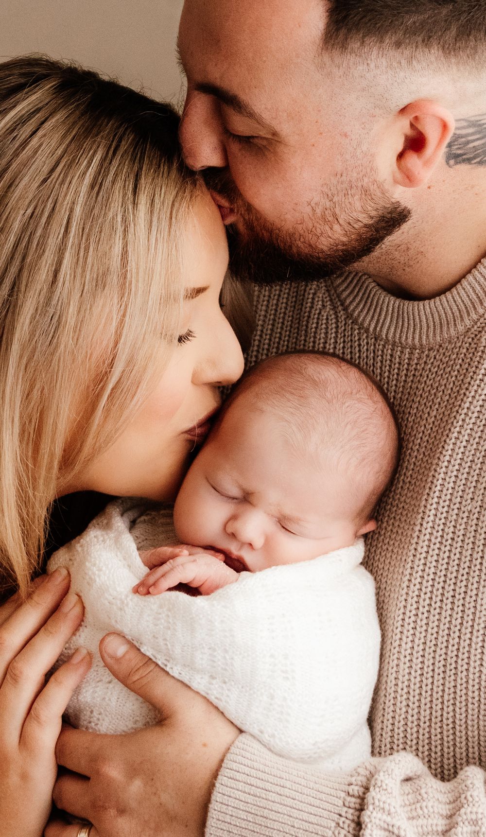 Close-up series of tender family moments with a baby wrapped in white blanket. Capturein a natural light studio in the blue mountains Sydney