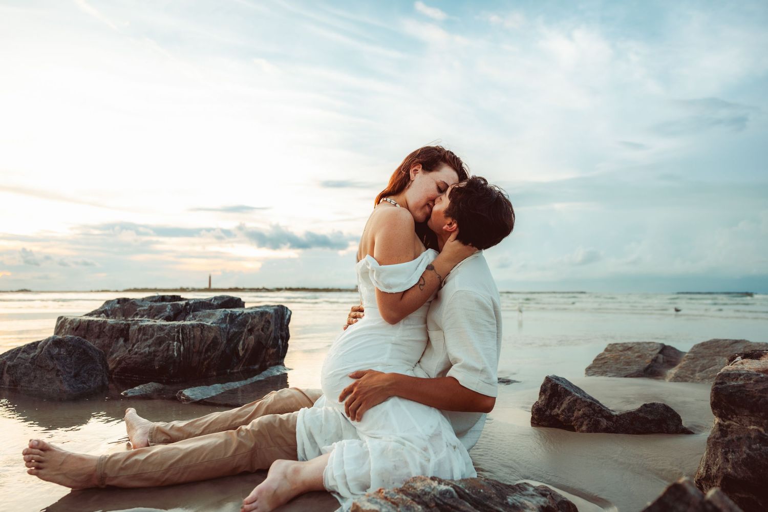 Sunset beach portrait with wedding dress silhouetted against ocean and driftwood.