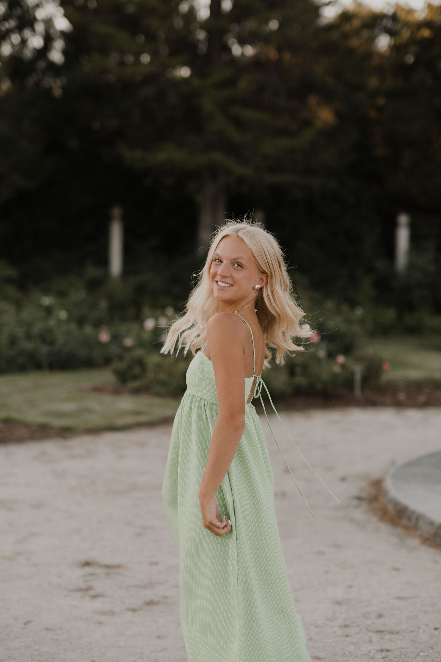 A flowing mint green dress captured in motion against a sandy beach background.