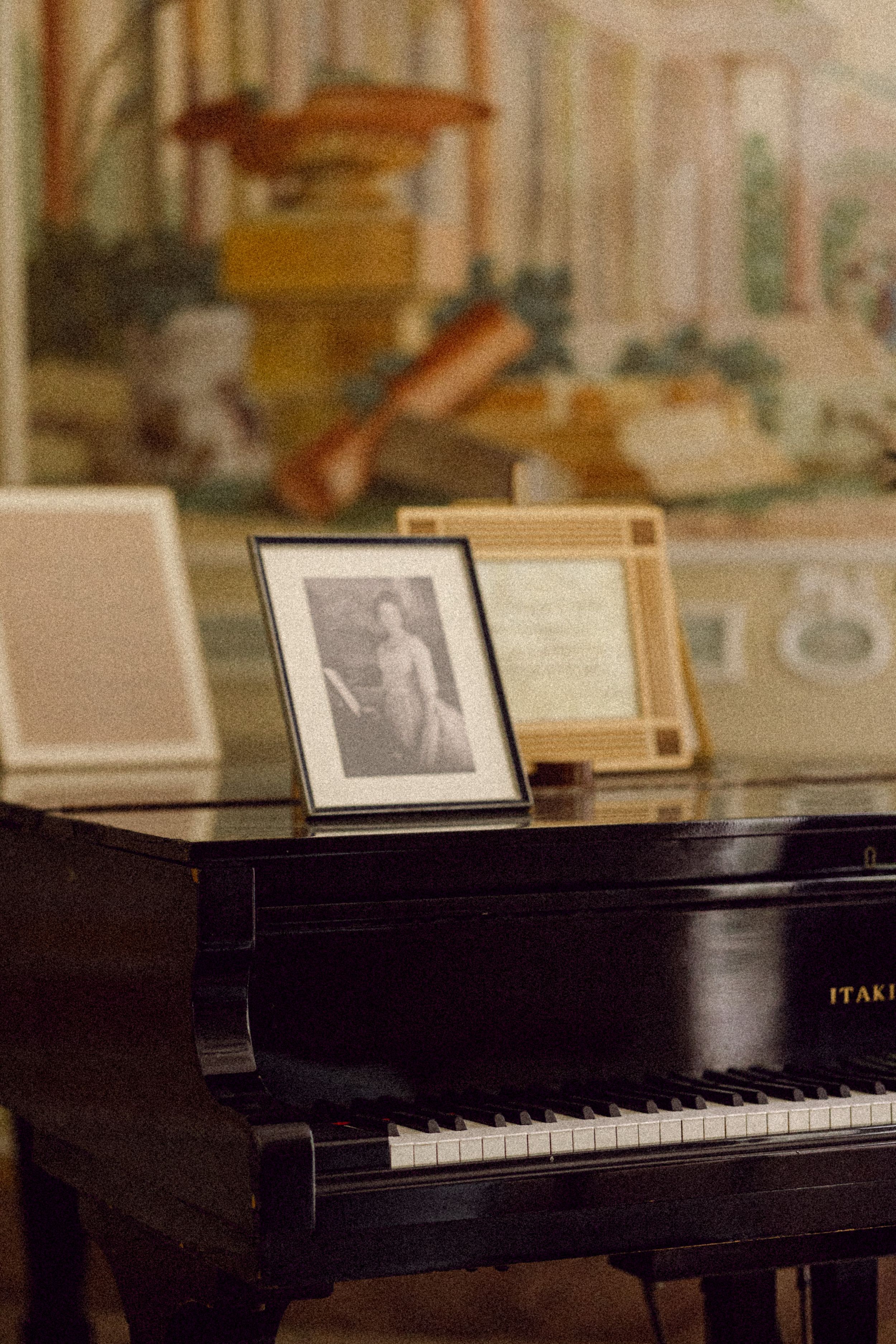 Vintage piano with framed photographs displayed on top in an elegant interior setting.