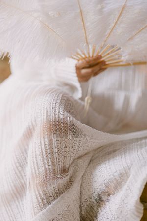Close-up of delicate white lace fabric with intricate patterns and textures.