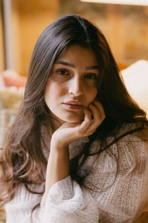 Soft portrait in warm lighting with lace detail and romantic styling.