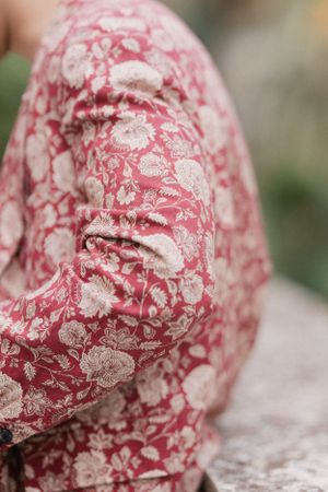 Close-up detail of a red and white floral patterned fabric with delicate lace-like design.