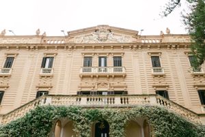 Elegant beige historic mansion with ornate architectural details and balconies.