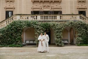 Wedding celebration at elegant villa with ivy-covered facade and classic architecture.