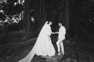 Romantic black and white wedding moment captured between trees.