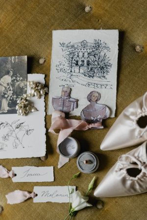 Vintage sketches and wedding accessories artfully arranged on a golden fabric background.