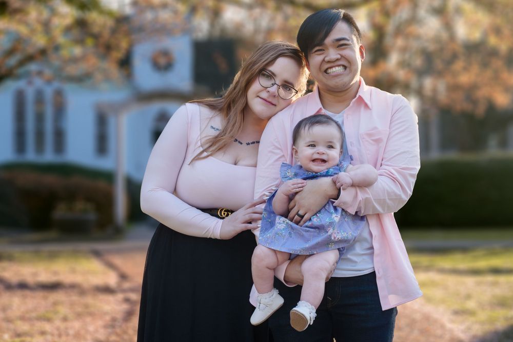 Happy family moment captured outdoors with natural lighting and greenery in background.