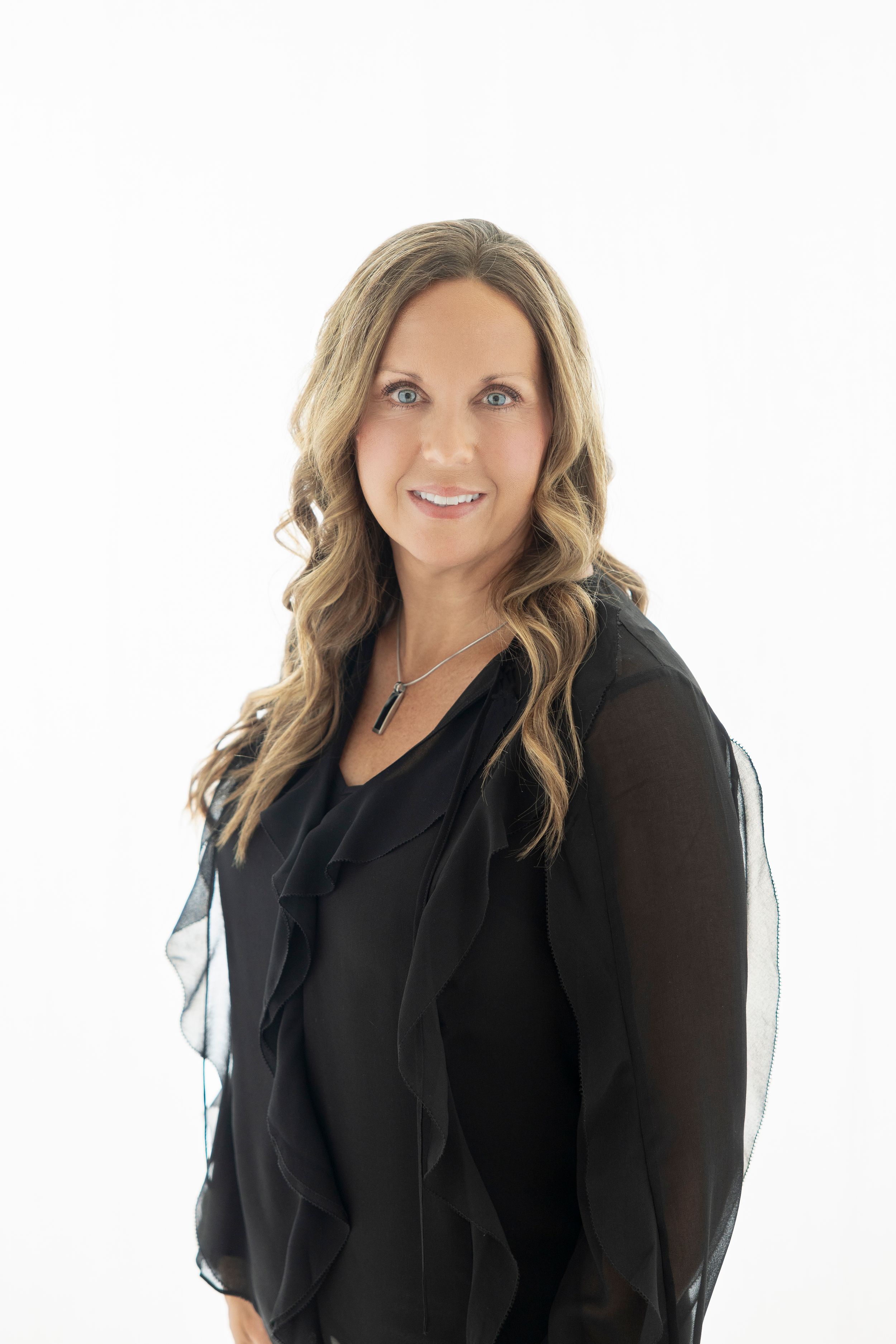 Professional woman in black blouse poses against white background.