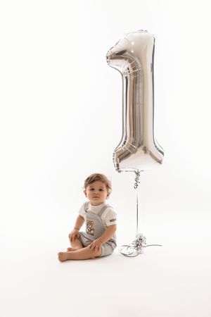 Baby boy with number one balloon in studio session