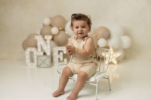 Baby boy enjoying her birthday cake during a professional studio cake smash session