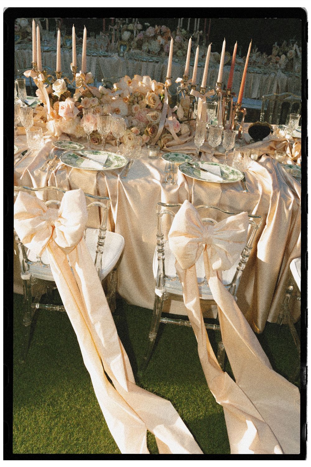Elegant and decadent wedding table setting with satin bows, candlelight and romantic floral details, creating a refined atmosphere