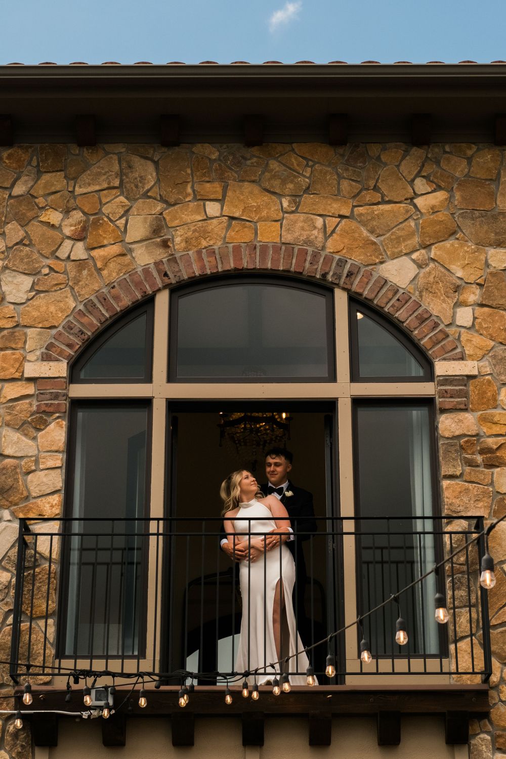 A couple enjoying the moments before walking down the aisle framed by the window they are standing on