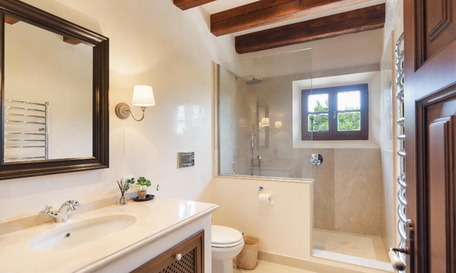 Contemporary bathroom with wooden beams, glass shower enclosure, and marble vanity.