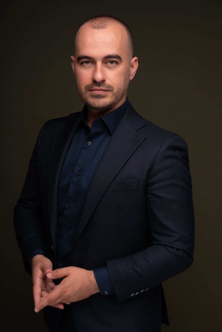 Headshot business in studio cu barbat intr-o tinuta business si postura increzatoare