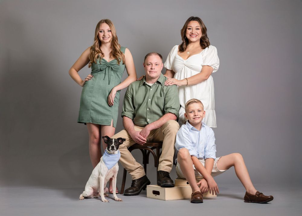 polished family portrait in calera alabama. studio setting with grey seamless background, mom, dad, daughter, son, and dog perfectly posed