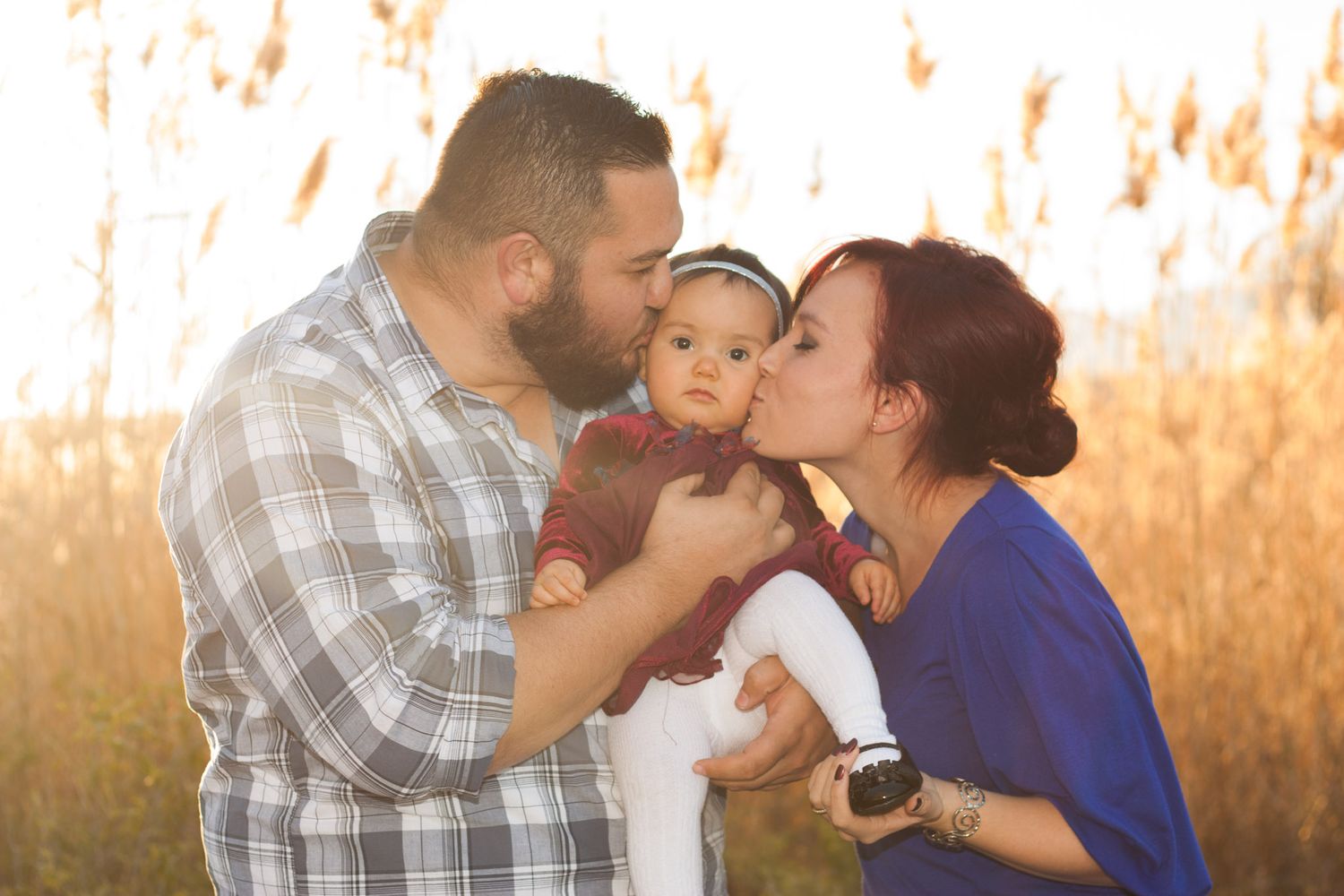 Family Portrait of mom, dad, and baby at sunset