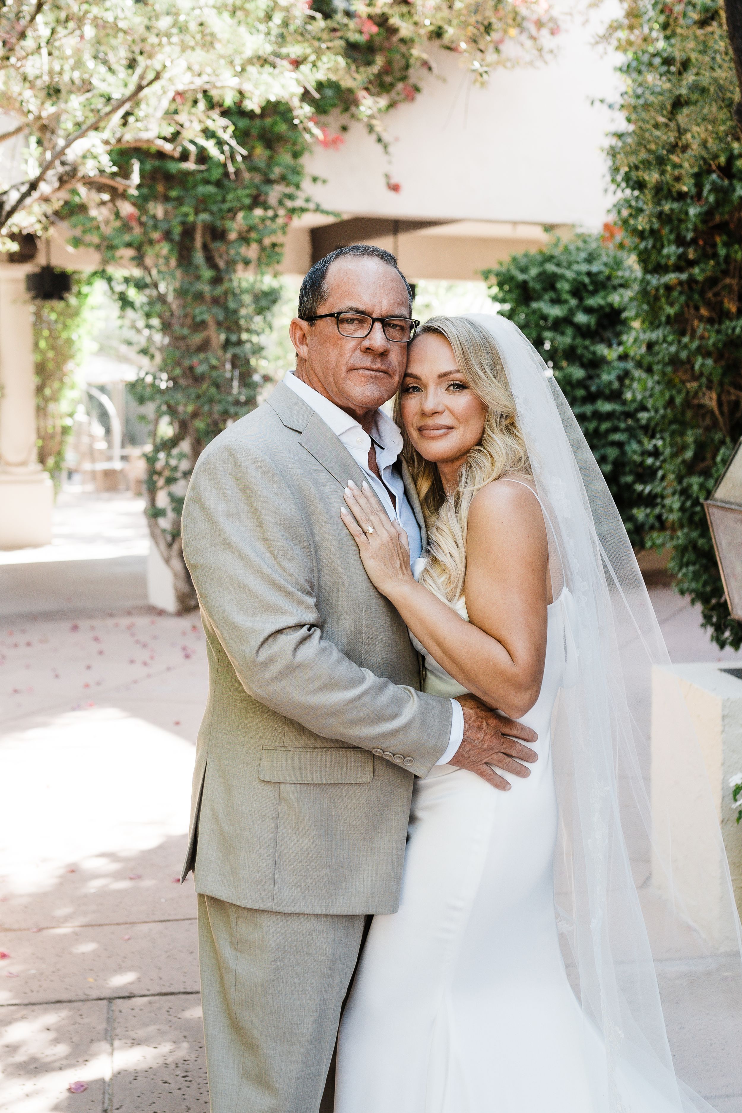 Elegant outdoor wedding portrait with beautiful garden backdrop and decorative lanterns.