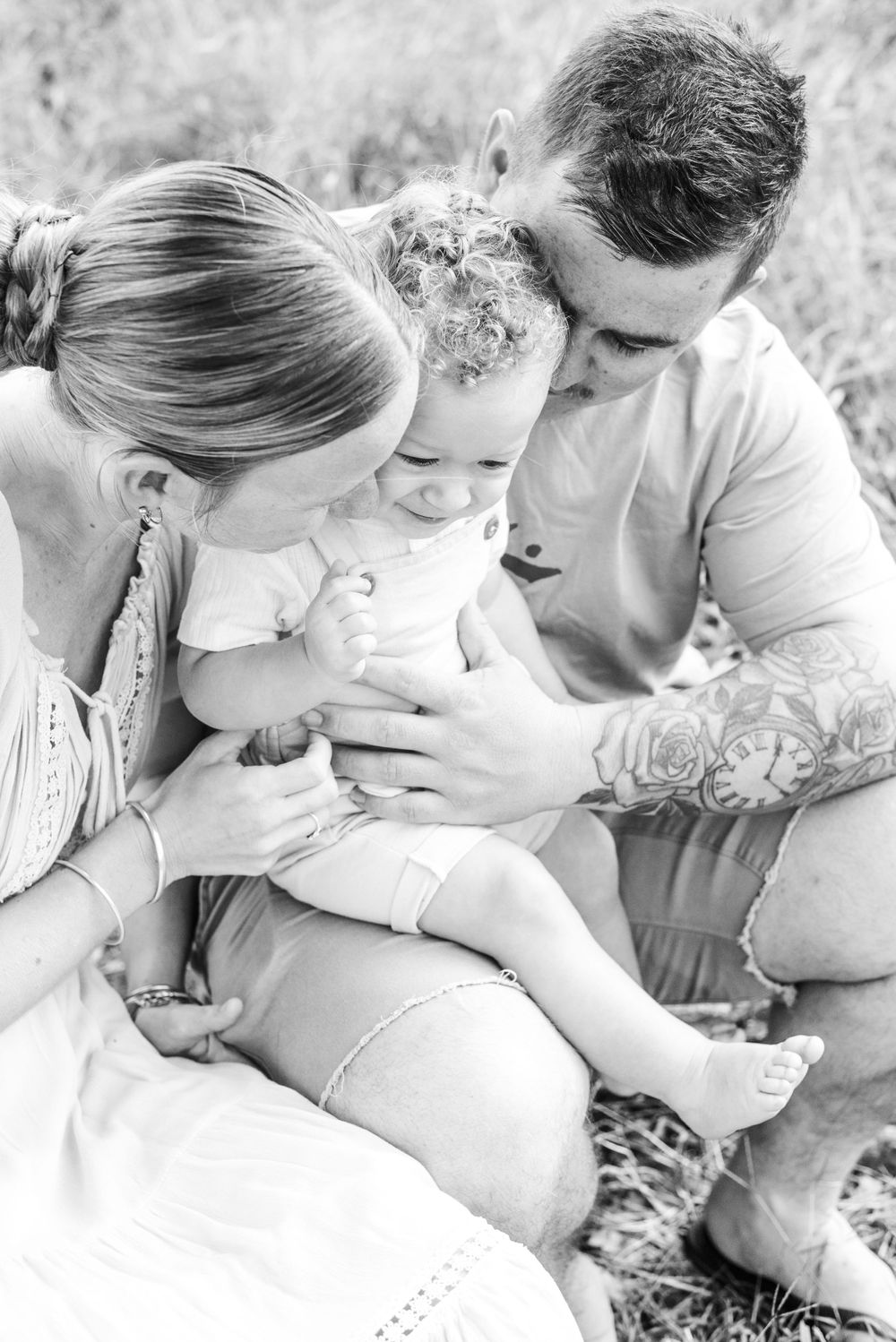 Intimate black and white family portrait showing tender moments shared outdoors.