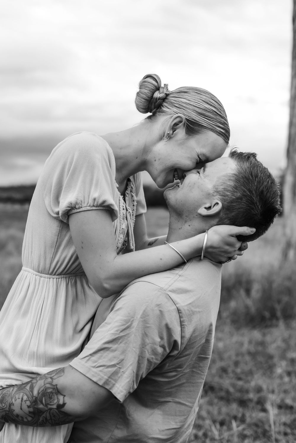 Romantic black and white portraits of a couple sharing intimate moments outdoors.