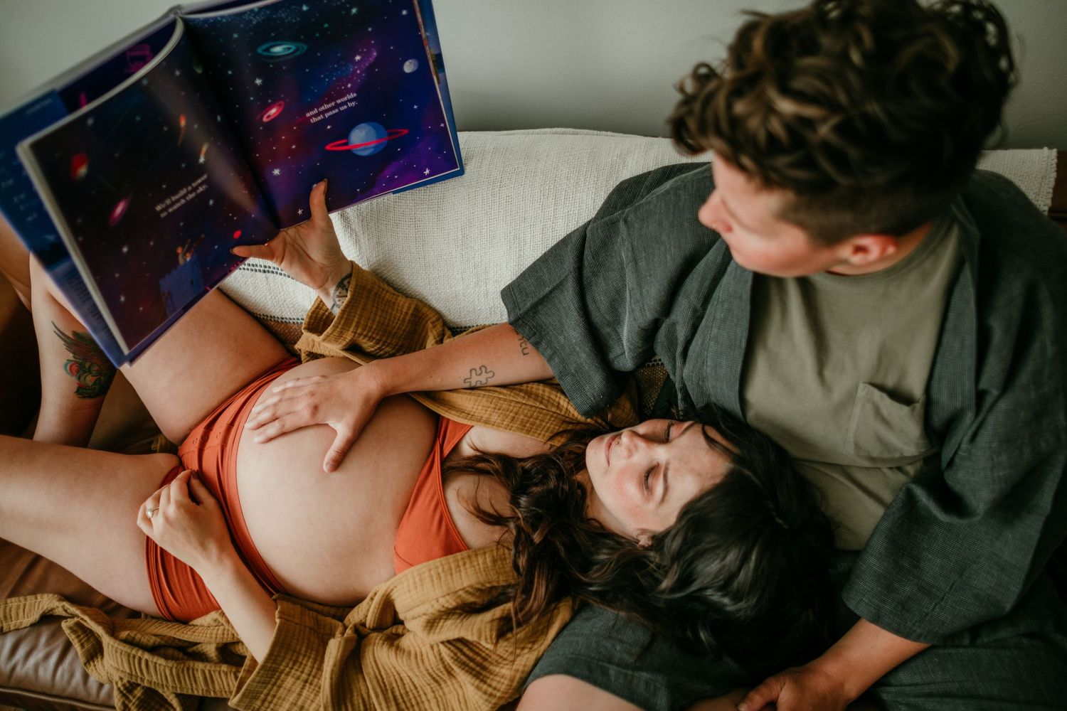 close up shot of couple reading book on couch portland oregon maternity photography rushes & waves