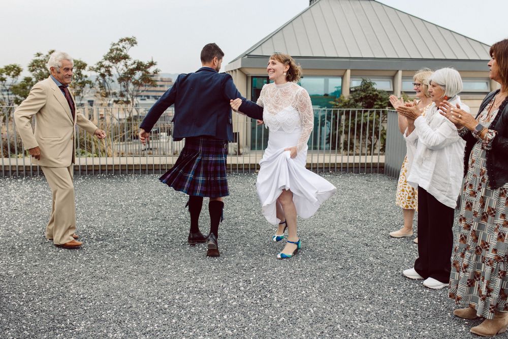 Wedding party celebrates on a gravel patio with scenic mountain views.