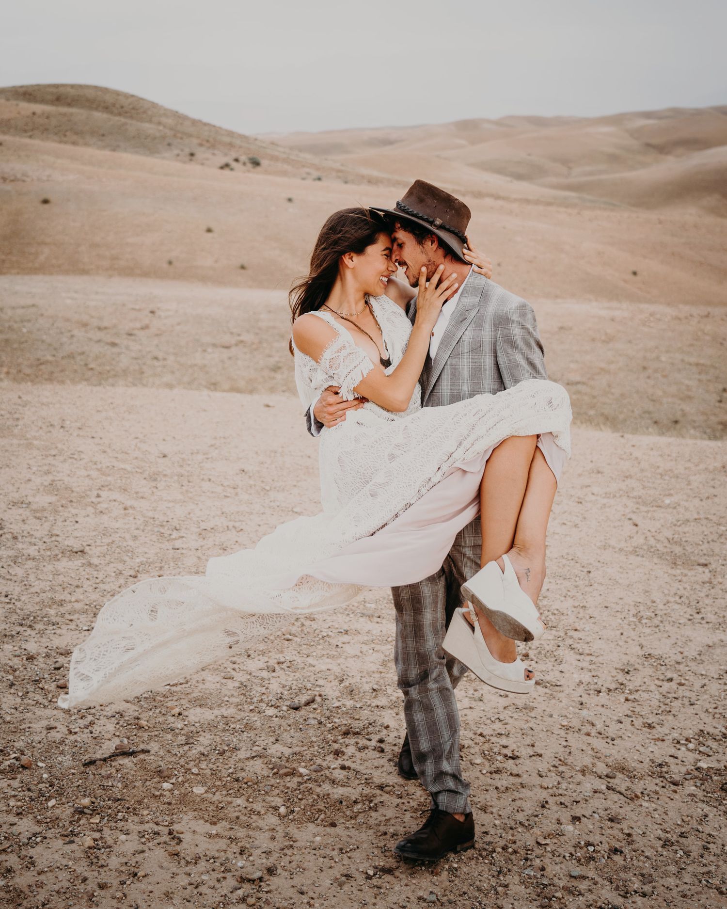 Romantic lift pose during desert wedding photoshoot.