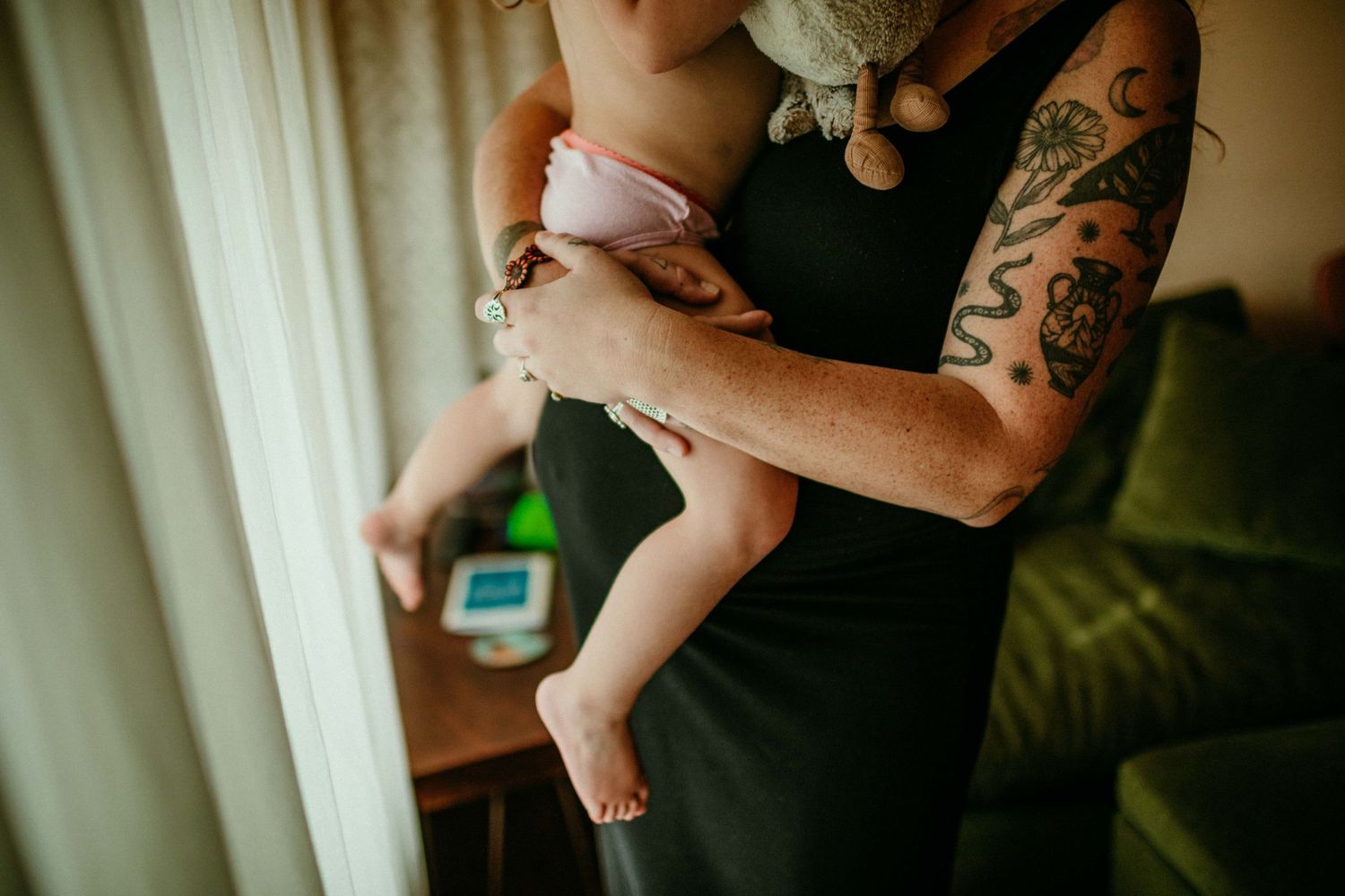 cropped image of childs legs in pregnant mothers arms portland oregon documentary family photography