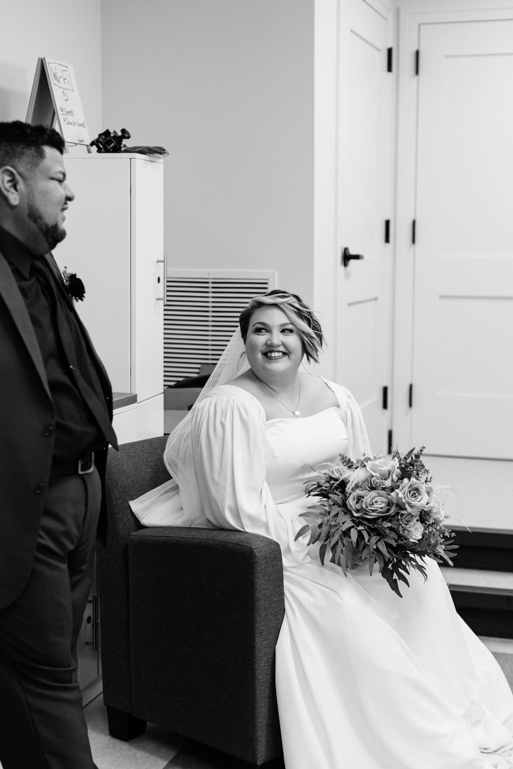 A black and white wedding photo captured in an indoor setting.