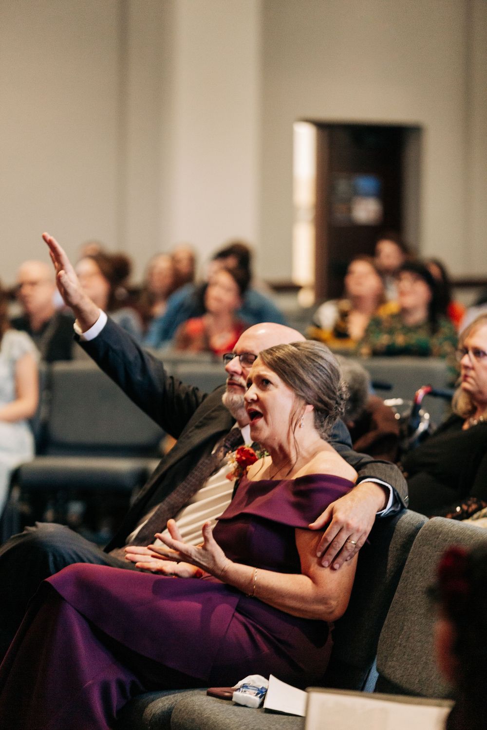 An emotional moment during a wedding ceremony as guests react from their seats.