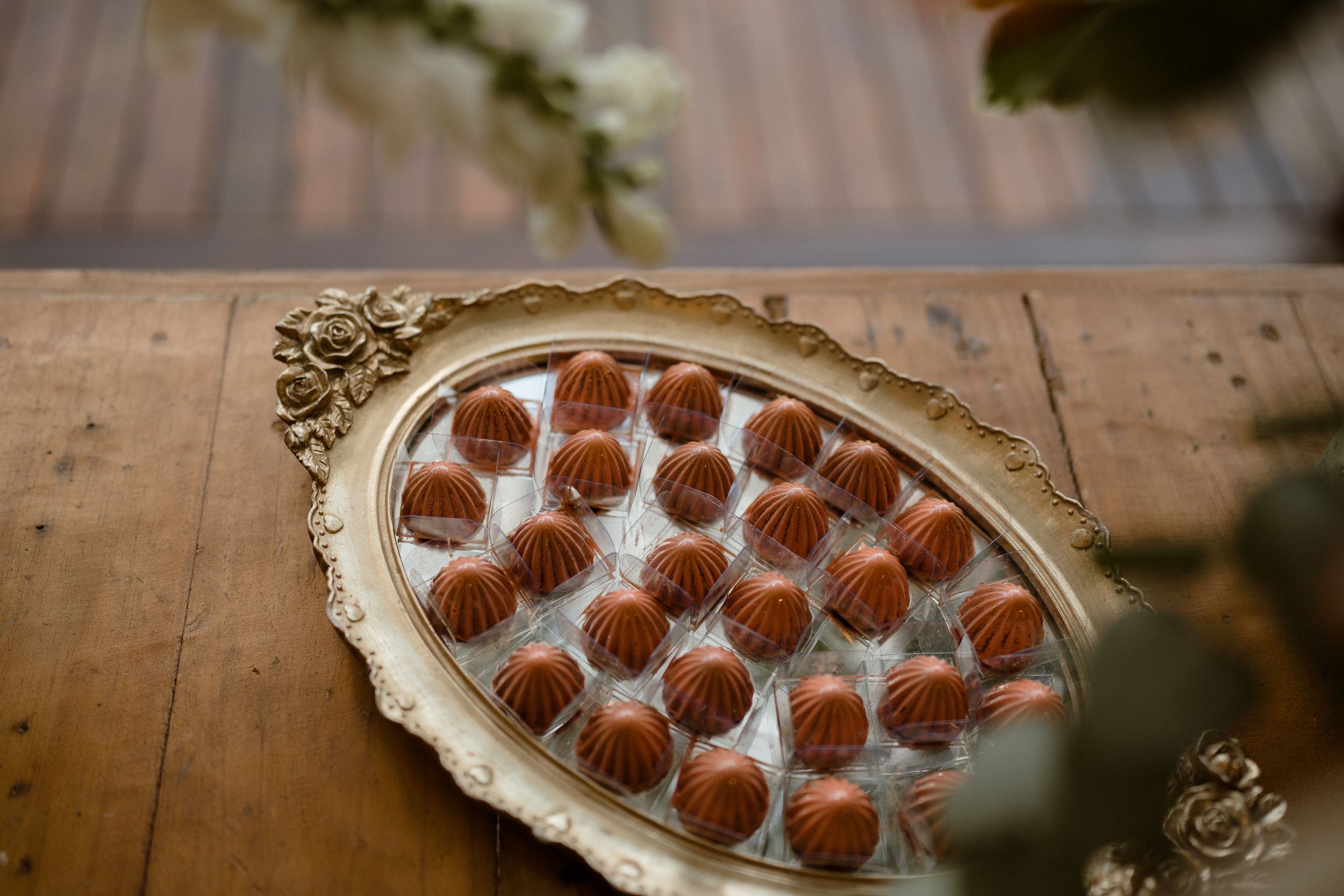 Elegantly arranged chocolate truffles on an ornate silver serving platter.