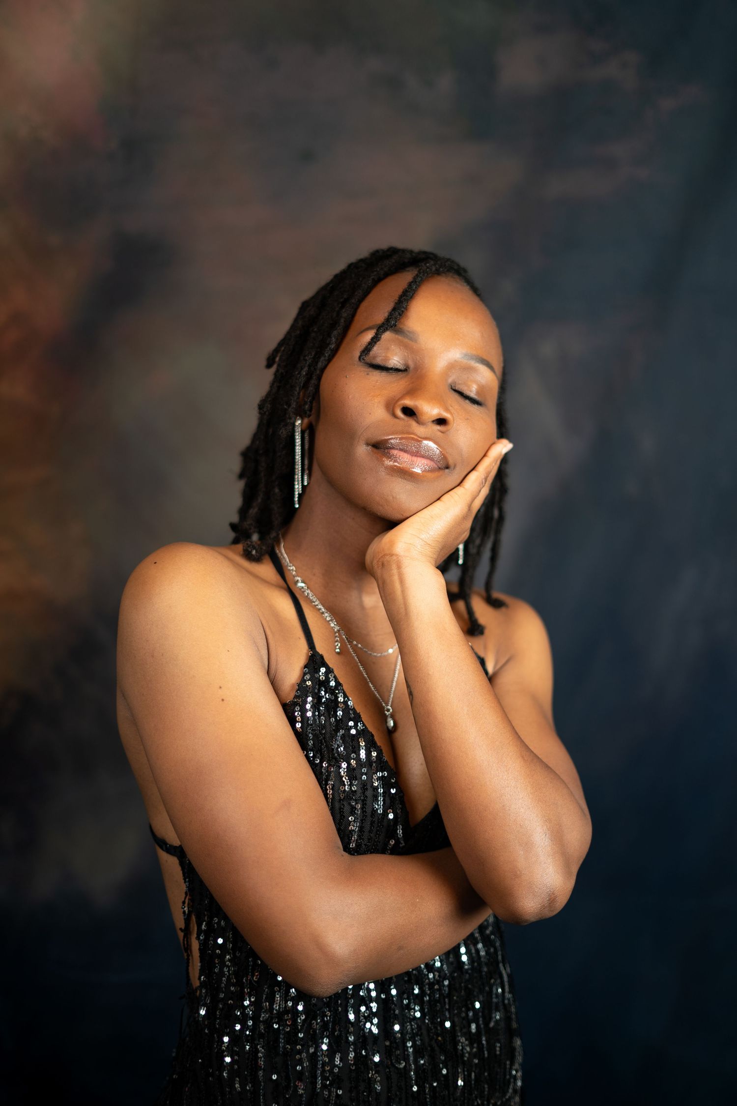 Dreamy fashion portrait with closed eyes pose in black sequined dress.